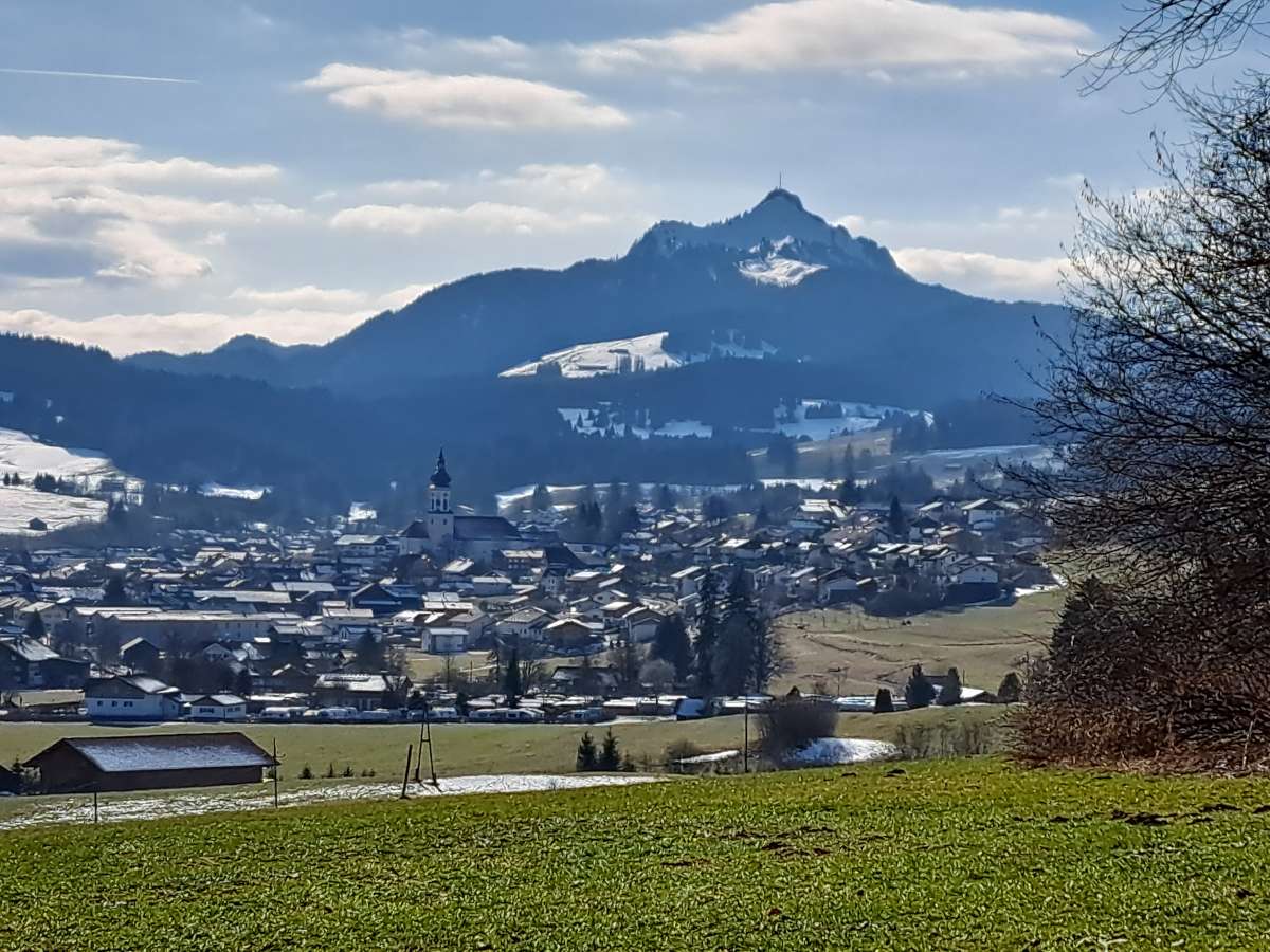 Das Dorf Wertach liegt in einer sonnigen Winterlandschaft, dahinter der schneebedeckte Grünten. Unsere Ferienwohnung liegt rechts von der Kirche auf der Anhöhe.