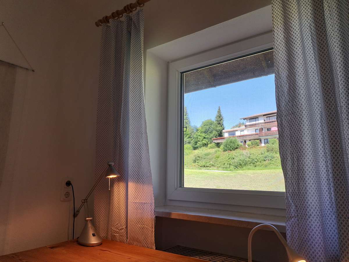 Schreibtisch im Einzelzimmer mit Blick auf die Wiese
