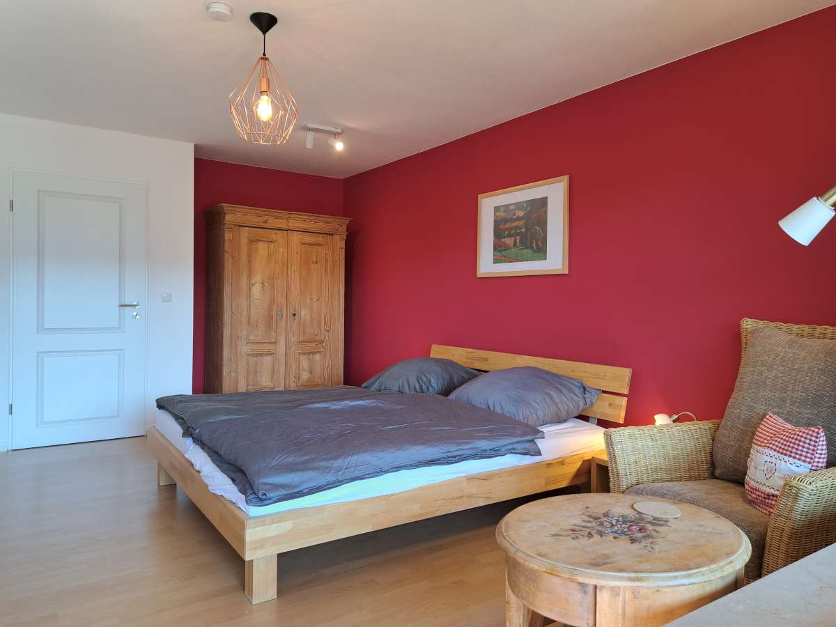 Das rote Schlafzimmer ist mit geschmackvollen Holzmöbeln eingerichtet
