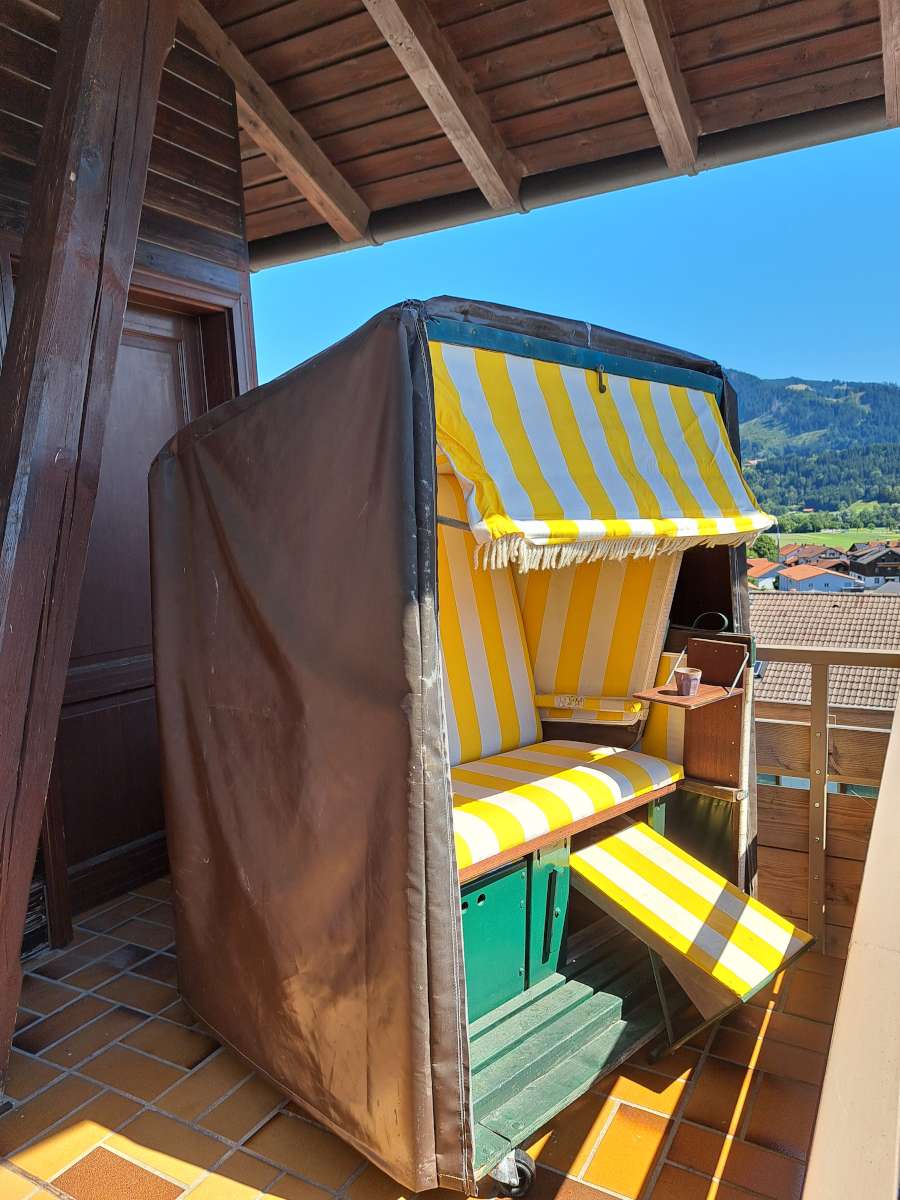 Strandkorb auf dem Balkon mit Aussicht auf die Berge